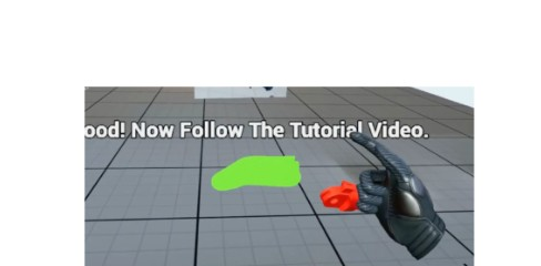 VR view with on-screen prompt to follow the tutorial video; virtual hand holding a red part near a green floor highlight.